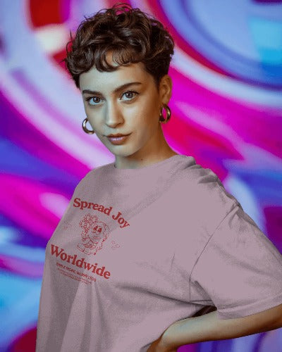 Person wearing a t-shirt with 'Spread Joy Worldwide' text against a colorful abstract background